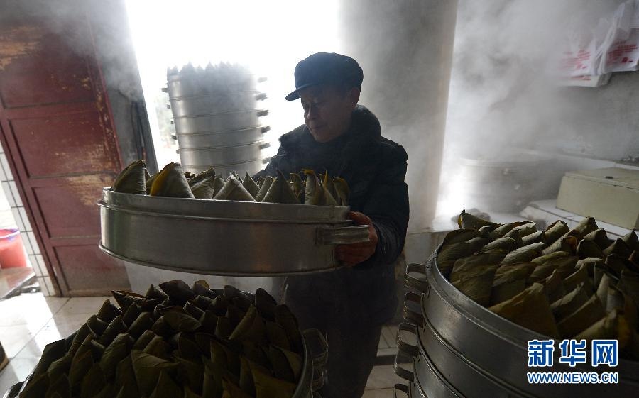 A man steams the corn-cakes. According to the traditional custom, people prepare special foods such as glutinous rice cake, soybean and corn candy in Xuanen county, Hubei province. (Xinhua/ Song Wen)
