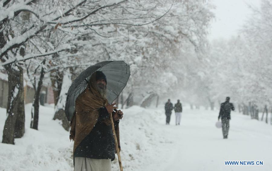 An Afghan man waits for transportation during heavy snowfall in Kabul, Afghanistan, on Feb. 2, 2013. Over the past two weeks, at least 17 people, 11 of them children, have died because of cold-related diseases in Afghanistan's resettlement areas, according to media reports. (Xinhua/Ahmad Massoud)