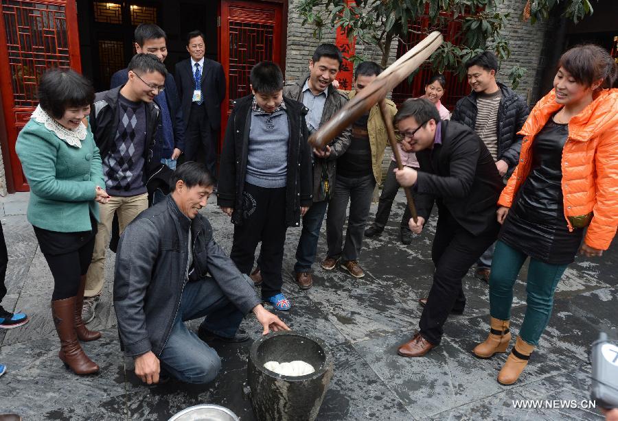 Villagers and tourists make glutinous rice pudding in Jiangwan Village of Wuyuan County, east China's Jiangxi Province, Feb. 4, 2013. Various traditional activities were held in Wuyuan to celebrate "Lichun", literally meaning the beginning of the spring, as well as the Xiaonian Festival which falls on the 23rd or 24th day of the 12th month of the Chinese traditional lunar calendar. (Xinhua/Song Zhenping)