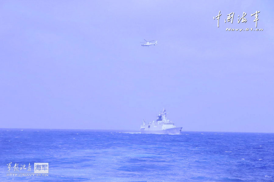 A warship and a helicopter attend antisubmarine training. (China Military Online/Ding Zengyi and Wang Lingshuo)