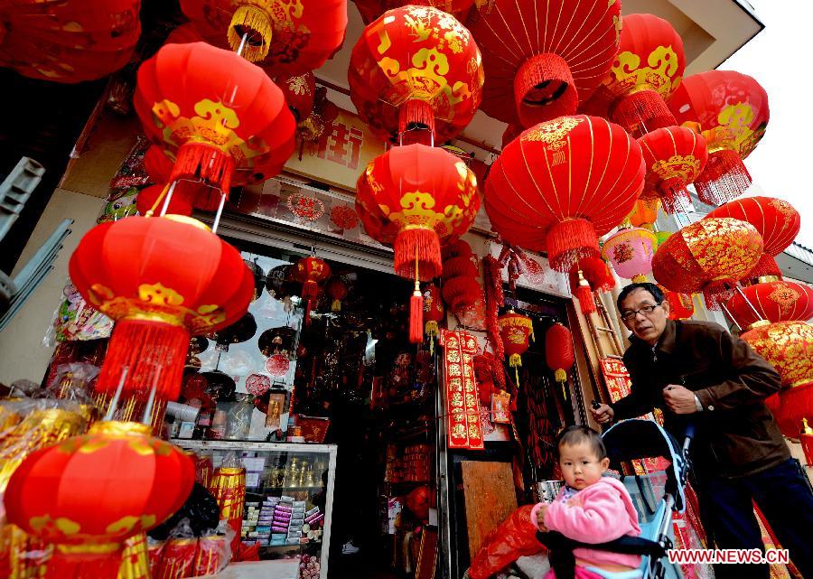 A man buy lanterns with a child to prepare for the coming Spring Festival in Fuzhou, southeast China's Fujian Province, Feb. 4, 2013. (Xinhua/Zhang Guojun) 