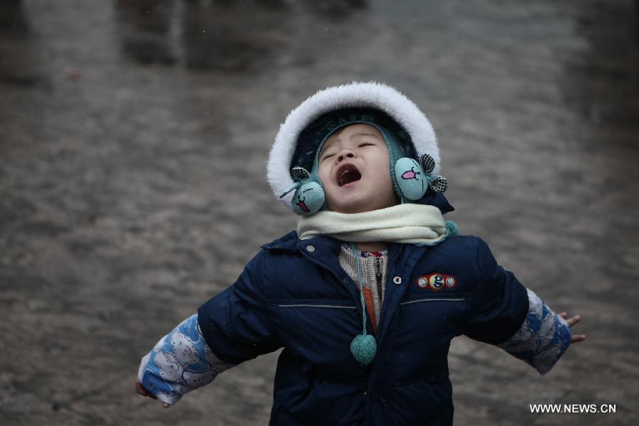 A child feels the snow with open arms at the Beijing train station in Beijing, capital of China, Feb. 3, 2013. Many children travel with their families during the 40-day Spring Festival travel rush which started on Jan. 26. The Spring Festival, which falls on Feb. 10 this year, is traditionally the most important holiday of the Chinese people. Public transportation is expected to accommodate about 3.41 billion trips nationwide during the holiday, including 225 million trips by railways. (Photo/Xinhua)