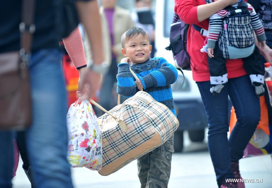 A little boy helps his mother carry a luggage bag at Nanning train station in Nanning, capital of south China's Guangxi Zhuang Autonomous Region, Feb. 3, 2013. Many children travel with their families during the 40-day Spring Festival travel rush which started on Jan. 26. The Spring Festival, which falls on Feb. 10 this year, is traditionally the most important holiday of the Chinese people. Public transportation is expected to accommodate about 3.41 billion trips nationwide during the holiday, including 225 million trips by railways. (Photo/Xinhua)