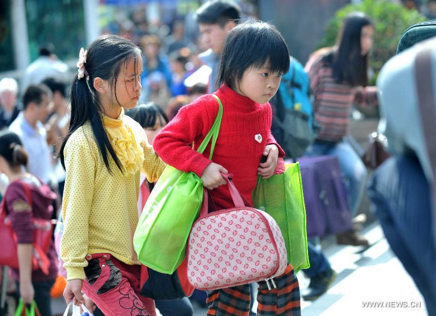Two girls carrying luggage enter the Nanning train station in Nanning, capital of south China's Guangxi Zhuang Autonomous Region, Feb. 3, 2013. Many children travel with their families during the 40-day Spring Festival travel rush which started on Jan. 26. The Spring Festival, which falls on Feb. 10 this year, is traditionally the most important holiday of the Chinese people. Public transportation is expected to accommodate about 3.41 billion trips nationwide during the holiday, including 225 million trips by railways. (Photo/Xinhua)