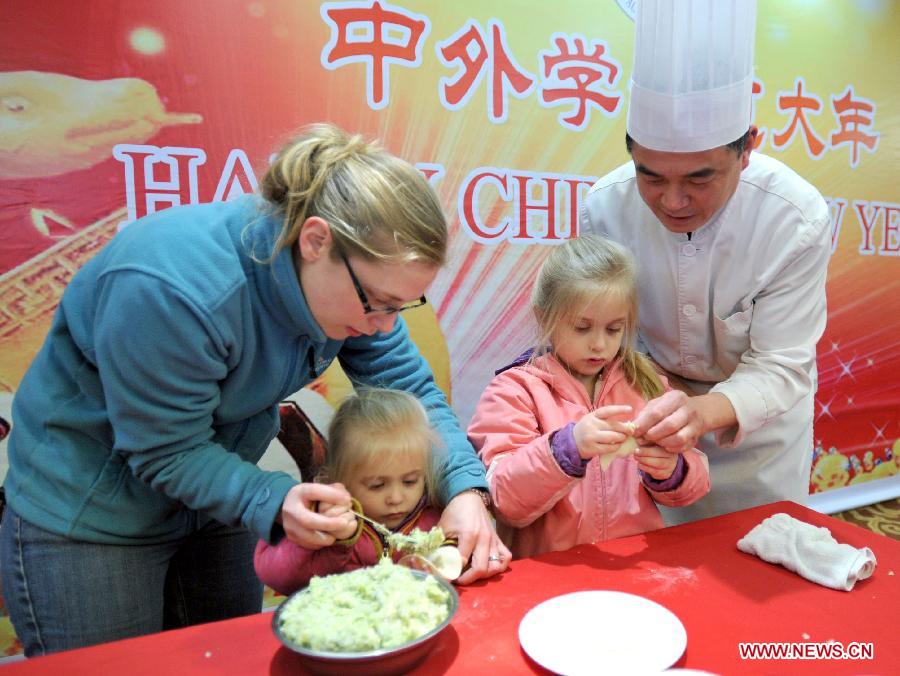 Children of an overseas student learn to make dumplings in an activity to celebrate the Chinese New Year at the Nanjing Agricultural University in Nanjing, capital of east China's Jiangsu Province, Feb. 4, 2013. More than 50 overseas students from over 20 countries and regions experienced Chinese traditional cultural activities with local students. (Xinhua)  