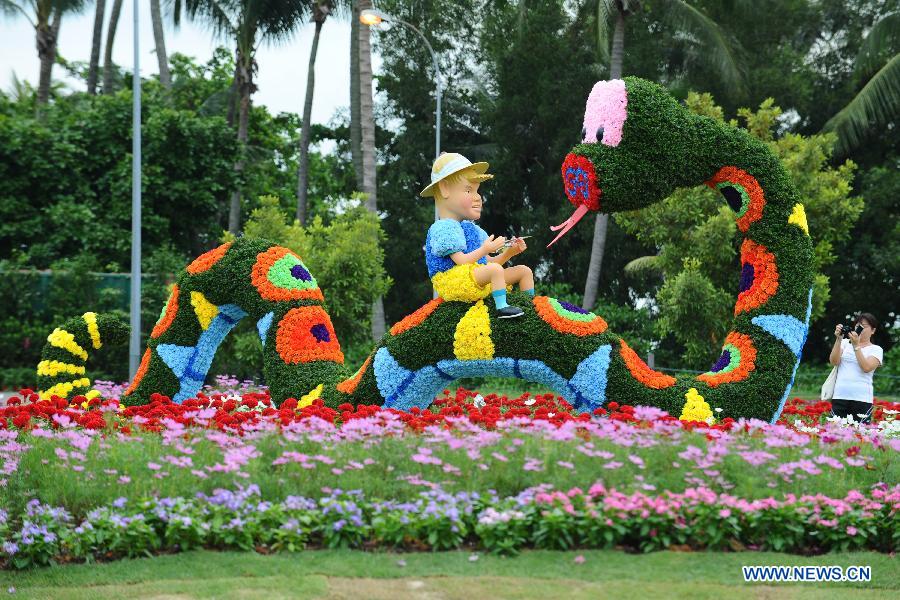 A tourist takes photos of the statue made of flowers on the Sentosa Island, Singapore, Feb. 4, 2013. The flower show on the Sentosa Island to celebrate the Spring Festival opens from Feb. 9 to 17. (Xinhua/Then Chih Wey) 
