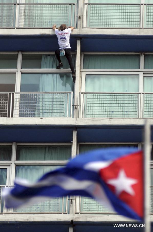 The so-called French Spiderman, Alain Robert, scales the landmark Havana Libre hotel without safety equipment in Havana, Cuba, on Feb. 4, 2013. (Xinhua/Joaquin Hernandez) 