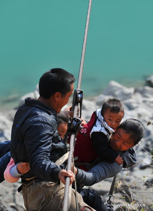 Residents from Shuangmidi Village cross the Nujiang River via a zip-line in Liuku County of Nujiang Lisu Autonomous Prefecture, southwest China's Yunnan Province, Feb. 2, 2013. More than 98 percent of Nujiang Lisu Autonomous Prefecture is occupied by mountains and valleys. The zip-lines have been quite popular transportation method along the Nujiang River since the ancient time. However, as transport conditions improve in recent years, a growing number of traditional zip-lines along the Nujiang River Valley have been dismantled or replaced by bridges. (Xinhua/Wang Changshan)