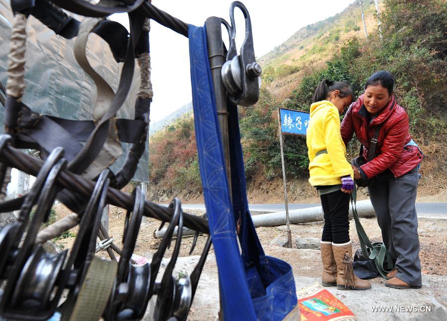 Residents from Shuangmidi Village make preparations before crossing the Nujiang River via a zip-line in Liuku County of Nujiang Lisu Autonomous Prefecture, southwest China's Yunnan Province, Feb. 2, 2013. More than 98 percent of Nujiang Lisu Autonomous Prefecture is occupied by mountains and valleys. The zip-lines have been quite popular transportation method along the Nujiang River since the ancient time. However, as transport conditions improve in recent years, a growing number of traditional zip-lines along the Nujiang River Valley have been dismantled or replaced by bridges. (Xinhua/Wang Changshan)
