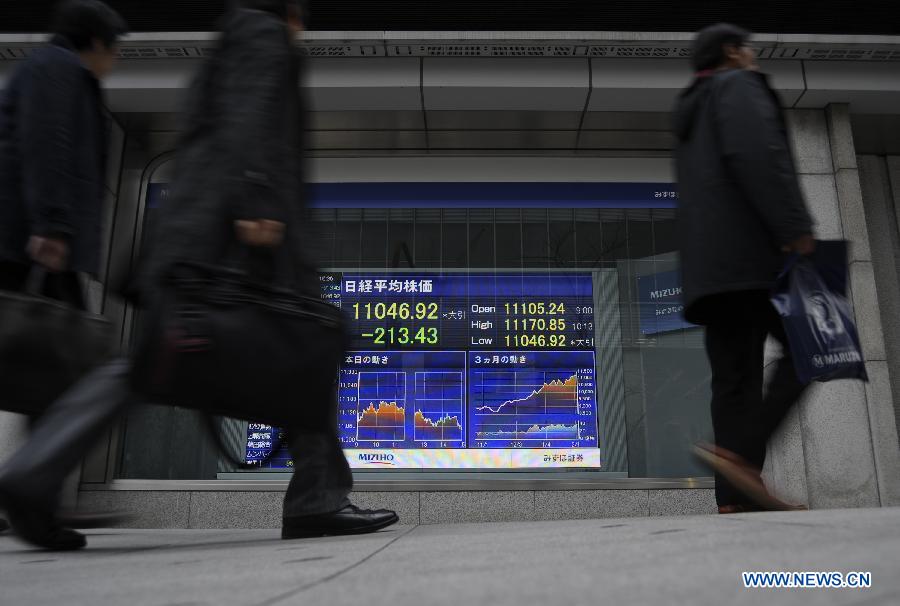 Pedestrians walk past an electronic board showing stock indexes in Tokyo, Japan, Feb. 5, 2013. Nikkei closed 1. 90 percent lower on Tuesday as market sentiment was dampened by political uncertainty in Europe. The 225-issue Nikkei Stock Average plunged 213.43 points, or 1. 90 percent, to 11,046.92. (Xinhua/Kenichiro Seki)