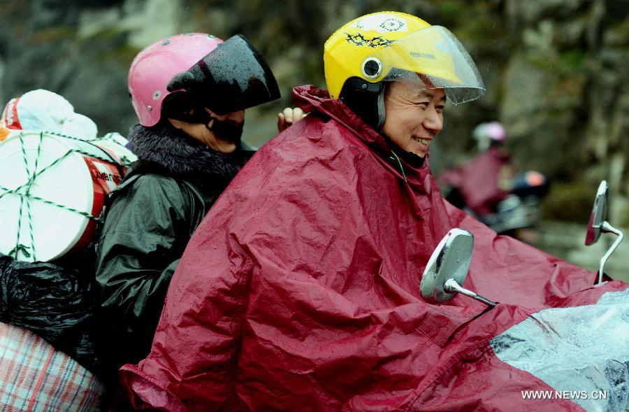 A migrant worker couple from east China's Jiangxi Province set forth a homebound motorcycle journey in Fuzhou, capital of southeast China's Fujian Province, Feb. 5, 2013. Many migrant workers in China choose motorcycle as the means of transport when they return to their hometowns for family reunion during the Spring Festival. (Xinhua/Zhang Guojun) 