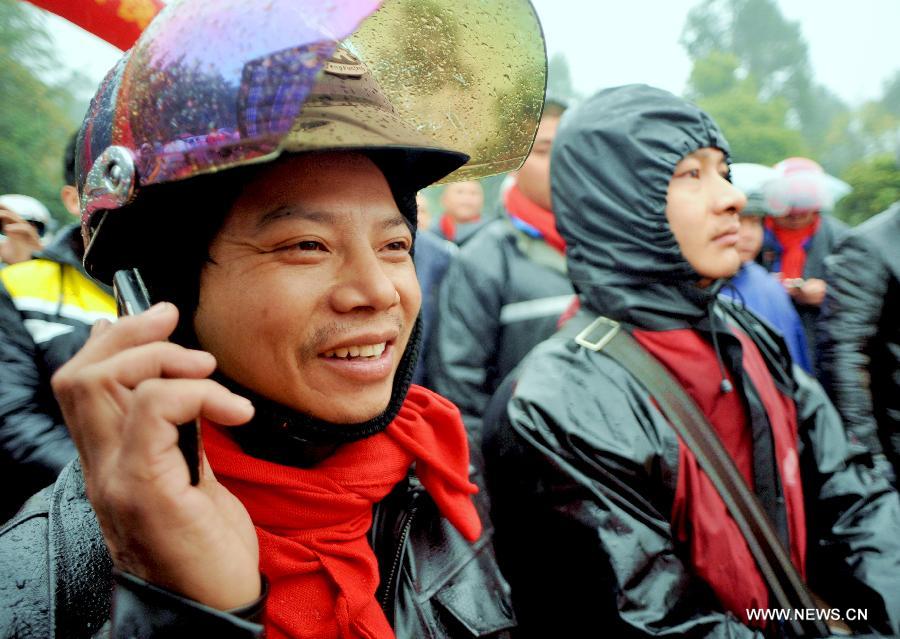 Wang Haigen, a migrant worker from east China's Jiangxi Province, makes a phone call to a family member at a gas station before a homebound motorcycle journey starts in Fuzhou, capital of southeast China's Fujian Province, Feb. 5, 2013. Many migrant workers in China choose motorcycle as the means of transport when they return to their hometowns for family reunion during the Spring Festival. (Xinhua/Zhang Guojun) 