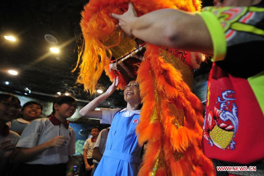 Students learn the Chinese traditional lion dance during a celebration of the Chinese Spring Festival at the Underwater World in Singapore, Feb. 5, 2013. (Xinhua/Then Chih Wey)