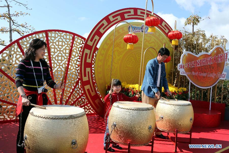 Tourists play drums in the newly-renovated Hong Kong Ocean Park in south China's Hong Kong, Feb. 5, 2013. The 2013 Lunar Lucky Fiesta will be held from Feb. 9 to 24 in the ocean park to celebrate the coming Chinese New Year of the Snake. (Xinhua/Li Peng)