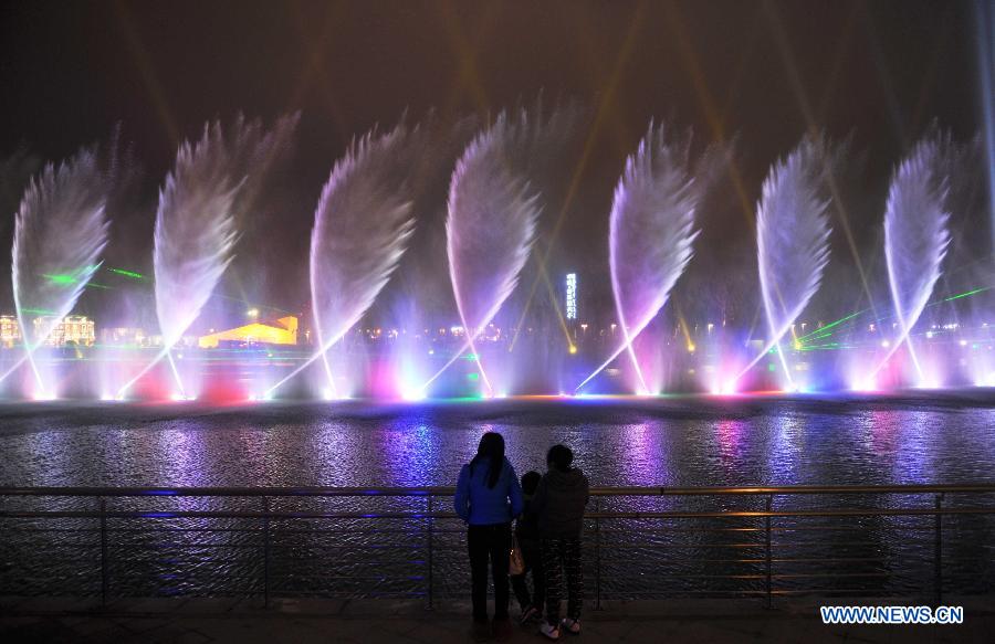 Visitors view the laser fountain during a lantern show in Changsha, capital of central China's Hunan Province, Feb. 5, 2013. The lantern show was held to greet the upcoming Spring Festival, or the Chinese Lunar New Year, which falls on Feb. 10 this year. (Xinhua/Li Ga)