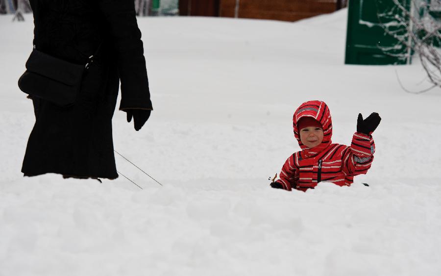 A kid plays in the snow in a park in Moscow, capital of Russia, on Feb. 5, 2013. A heavy snow hit Moscow on Sunday. (Xinhua/Jiang Kehong)