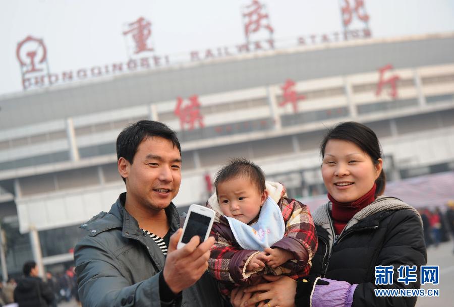 Zhang Meng(middle) and her parents pose for a photo at the square of Chongqing Railway North Station on Jan. 26, 2013. (Xinhua)