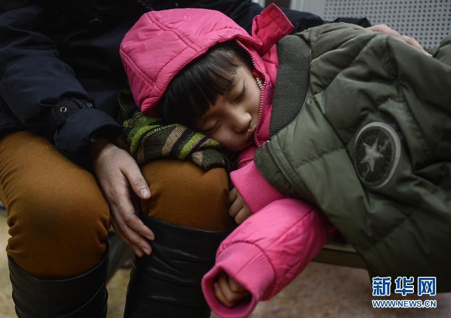 A girl falls asleep while waiting for the train to Qiqihar in the waiting room of Hangzhou Railway Station. (Xinhua/Han Chuanhao)