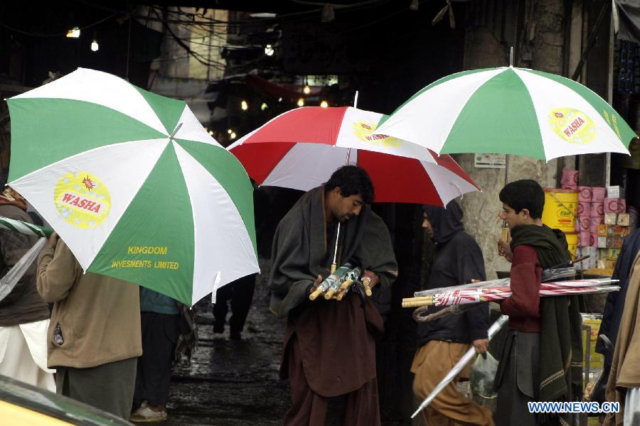 People hold umbrellas in northwest Pakistan's Peshawar Feb. 6, 2013. At least 17 people were killed, 31 injured and many others displaced after moderate to heavy rainfall lashed several areas of Pakistan over the last 72 hours, local TV Dunya reported on Tuesday. (Xinhua/Umar Qayyum)