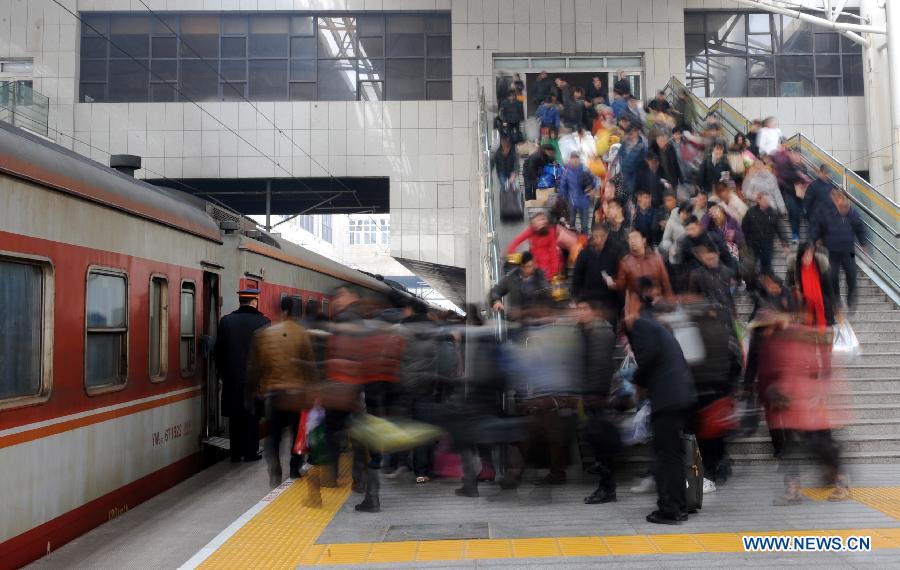 Passengers board a train at the Zhengzhou Railway Station in Zhengzhou, capital of central China's Henan Province, Feb. 5, 2013. China's transport system sees an annual travel rush around the Spring Festival, which starts on Feb. 10 this year. (Xinhua/Li Bo)