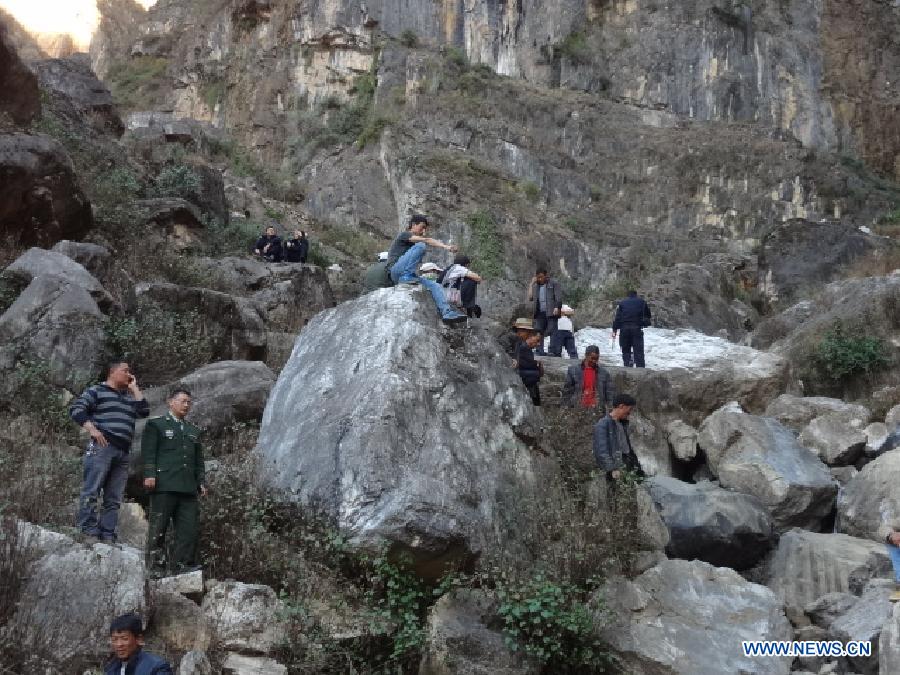 People gather around the site of road accident in Wumeng Township under an industrial and tourist development zone near Kunming, capital of Yunnan, on Feb. 6, 2013. Twelve people were killed and three others injured after a vehicle fell off a mountain cliff in Yunnan Province on Wednesday afternoon. (Xinhua)