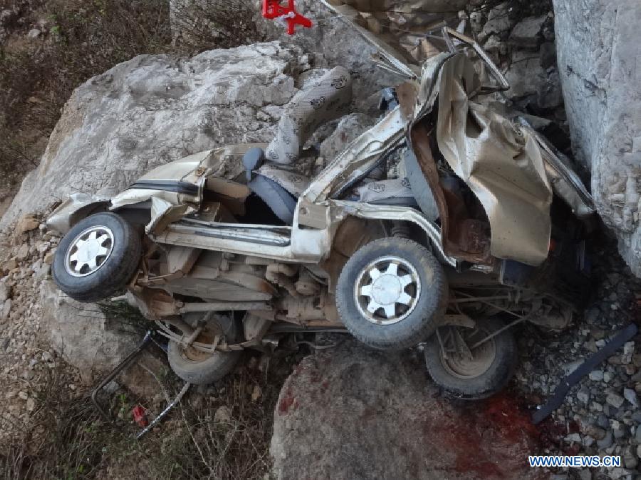 The remain of the damaged vehicle can be see at the site of road accident in Wumeng Township under an industrial and tourist development zone near Kunming, capital of Yunnan, on Feb. 6, 2013. Twelve people were killed and three others injured after a vehicle fell off a mountain cliff in Yunnan Province on Wednesday afternoon. (Xinhua)