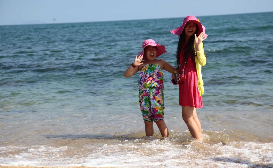 Visitors play on the seashore in Sanya, south China's Hainan Province, Feb. 5, 2013. (Xinhua/Chen Wenwu)