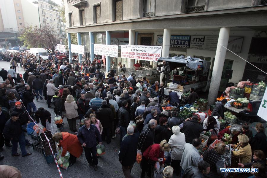 People queue for a free distribution of fruits and vegetables from the farmers outside Greece's Agriculture Ministry in Athens, Greece, on Feb 6, 2013. Greek farmers continued on Wednesday their 10-day protests against tax hikes while distributing tons of vegetables and fruits for free to needy citizens. (Xinhua/Marios Lolos)