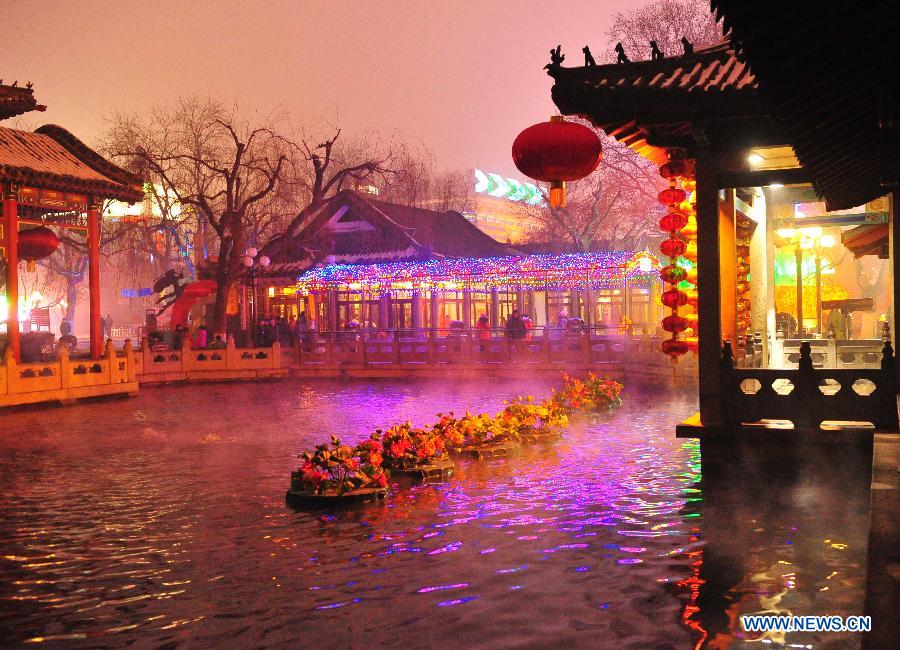 Local citizens look at festive lanterns at a lantern show in Baotuquan Park of Jinan, capital of east China's Shandong Province, Feb. 6, 2013. The 34th Baotuquan Spring Festival lantern show kick off on Wednesday at the park. (Xinhua)