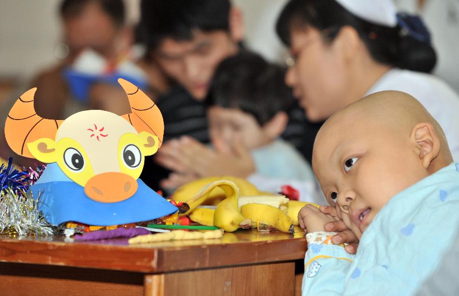 TIANJIN, Feb. 6, 2013 (Xinhua) -- A little patient crouching over a desk watches performance at Tianjin Medical University Cancer Institute and Hospital in north Tianjin's Municipality, Feb. 6, 2013. A Spring Festival party is held at the hospital on Wednesday for children receiving treatment and not returning home during the festival. The 2013 Spring Festival, which falls on Feb. 10, is traditionally the most important holiday of the Chinese people. (Xinhua/Yue Yuewei)