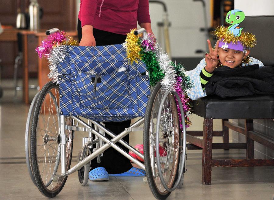 TIANJIN, Feb. 6, 2013 (Xinhua) -- A little patient from Dongying of east China's Shandong Province lies on a bench to watch performance at Tianjin Medical University Cancer Institute and Hospital in north Tianjin's Municipality, Feb. 6, 2013. A Spring Festival party is held at the hospital on Wednesday for children receiving treatment and not returning home during the festival. The 2013 Spring Festival, which falls on Feb. 10, is traditionally the most important holiday of the Chinese people. (Xinhua/Yue Yuewei)