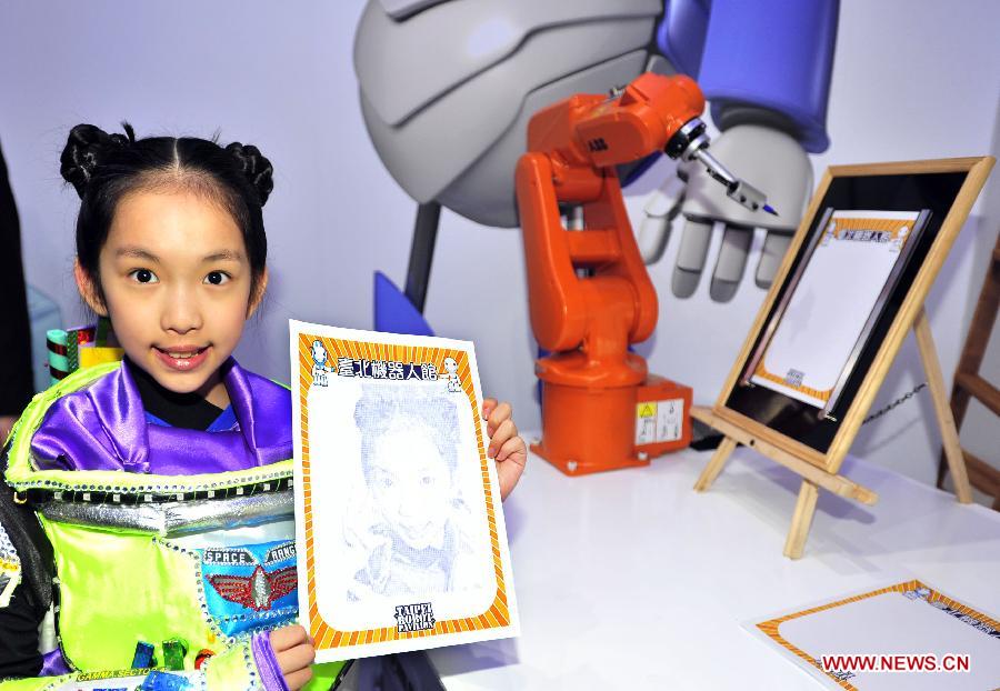 A young visitor demonstrates the work of a portraitist robot in a newly inaugurated robot pavilion at Taipei Expo Park in Taipei, southeast China's Taiwan, Feb. 6, 2013. The robot pavilion was inaugurated Wednesday at the Xinsheng Park of Taipei Expo Park. The facility features 60 robotic exhibits. (Xinhua/Wu Ching-teng) 