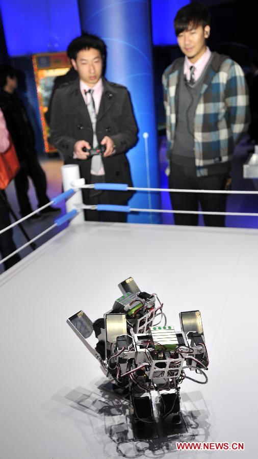 A visitor watches a robot battle in a newly inaugurated robot pavilion at Taipei Expo Park in Taipei, southeast China's Taiwan, Feb. 6, 2013. The robot pavilion was inaugurated Wednesday at the Xinsheng Park of Taipei Expo Park. The facility features 60 robotic exhibits. (Xinhua/Wu Ching-teng)