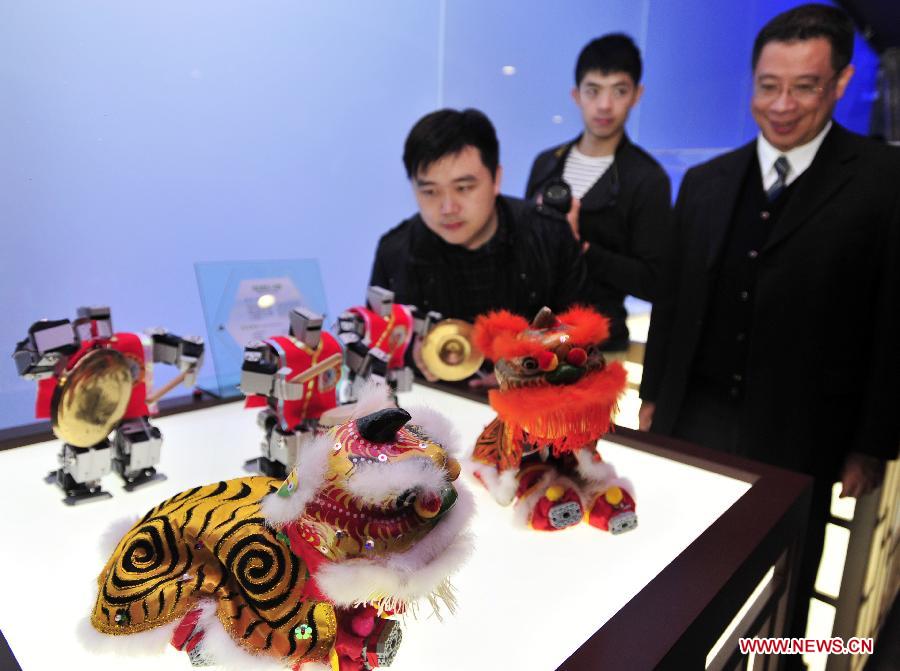 Visitors look at a robot lion dance team in a newly inaugurated robot pavilion at Taipei Expo Park in Taipei, southeast China's Taiwan, Feb. 6, 2013. The robot pavilion was inaugurated Wednesday at the Xinsheng Park of Taipei Expo Park. The facility features 60 robotic exhibits. (Xinhua/Wu Ching-teng) 