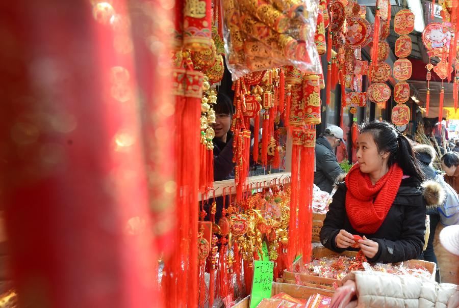 A local Chinese looks at the traditional decorations for the upcoming Chinese Lunar New Year in China Town, New York, the United States, Feb. 6, 2013. The Chinese Lunar New Year, or Spring Festival, starts on Feb. 10 this year. (Xinhua/Wang Lei)  