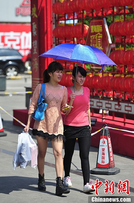 People go out in summer dress in Hainan on Feb. 6, 2013. The temperature of Hainan province rose to 30 degrees Celsius. People and travelers felt a different hot winter here. (Photo/Chinanews)