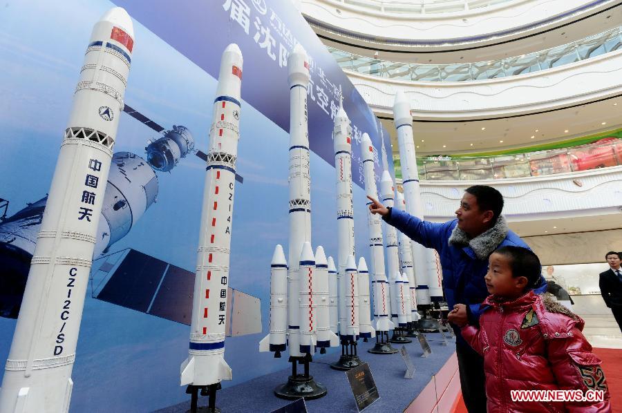 Visitors look at rocket models presented on the First Shenyang Aerospace Science Exhibition in Shenyang, capital of northeast China's Liaoning Province, Feb. 7, 2013. Space food, devices, models of Shenzhou spacecraft and China-developped rockets are among the exhibits. (Xinhua/Zhang Wenkui)