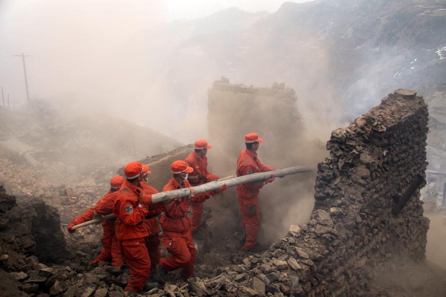 Soldiers clean dilapidated buildings at the scene of a fire in Heiduo Village of Diebu County in northwest China's Gansu Province, Feb. 7, 2013. The fire broke out in Heiduo Village around 8 p.m. and was put out Thursday morning, leaving destruction of 92 homes and no casualties. (Xinhua/Liu Wenchao)