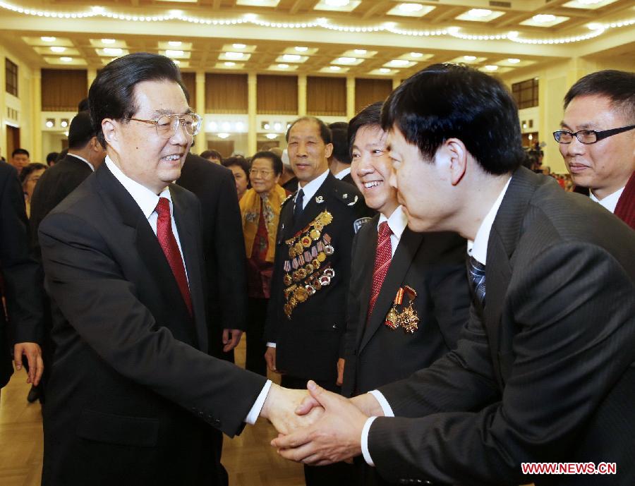 Chinese President Hu Jintao (L) shakes hands with a participant at a Spring Festival reception held by the Central Committee of the Communist Party of China and the State Council (Cabinet) at the Great Hall of the People in Beijing, capital of China, Feb. 8, 2013. (Xinhua/Ju Peng) 