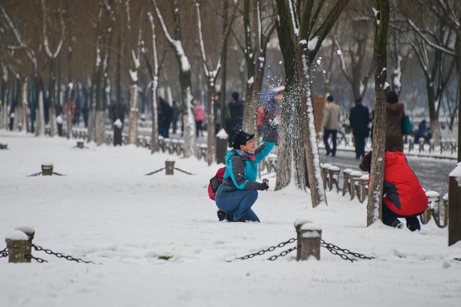 Tourists have fun with snow by the West Lake in Hangzhou, capital of east China's Zhejiang Province, Feb. 8, 2013. A big range of snowfall enveloped Zhejiang Province on Friday. (Xinhua/Xu Yu) 