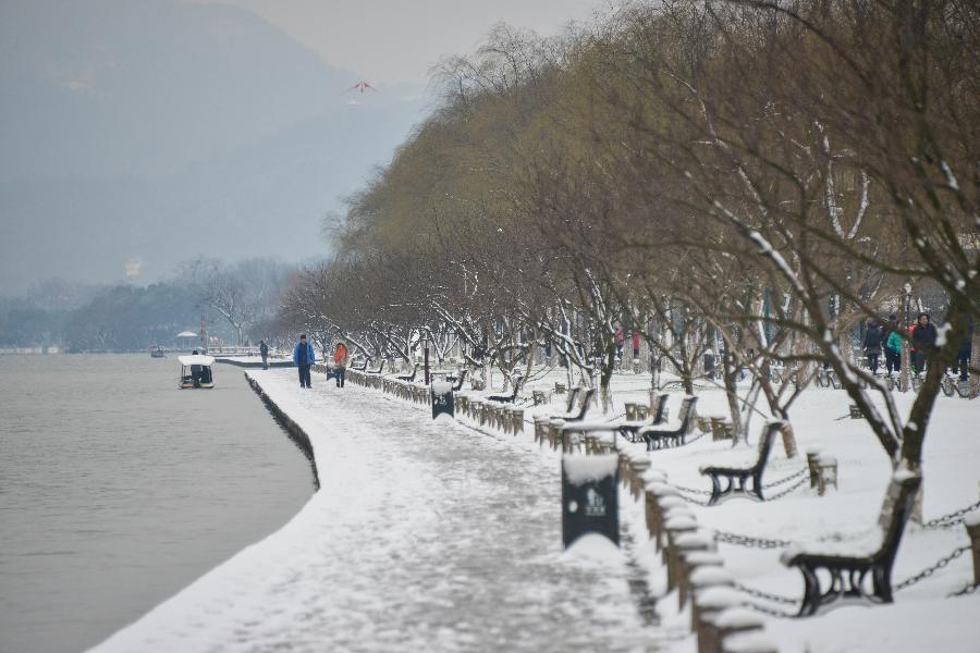 Tourists wonder by the West Lake after a snowfall in Hangzhou, capital of east China's Zhejiang Province, Feb. 8, 2013. A big range of snowfall enveloped Zhejiang Province on Friday. (Xinhua/Xu Yu) 