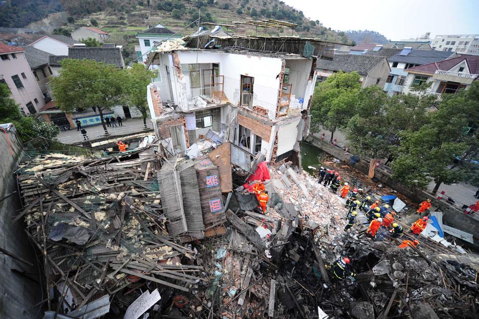 Rescuers search for the missing people in the debris at the accident site of a suspected boiler explosion in a noodle shop in Cixi, east China's Zhejiang province, Feb. 3, 2013. Five people were killed and six others injured in the accident. The three-floor building partially collapsed in the accident.(Xinhua) 