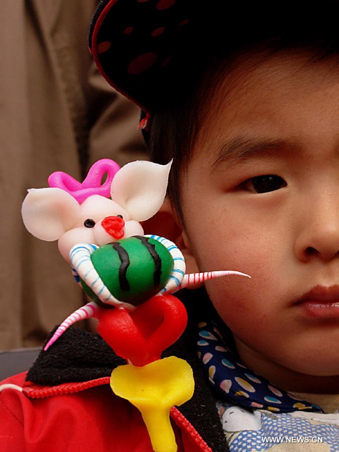 File photo taken on Feb. 21, 2007 shows a boy holding a dough figurine of pig in a temple fair in Zhengzhou, capital of central China's Henan Province. 2007 was the Year of the Pig in the Chinese Zodiac. Chinese Zodiac is represented by 12 animals to record the years and reflect people's attributes, including the rat, ox, tiger, rabbit, dragon, snake, horse, sheep, monkey, rooster, dog and pig. (Xinhua/Wang Song) 