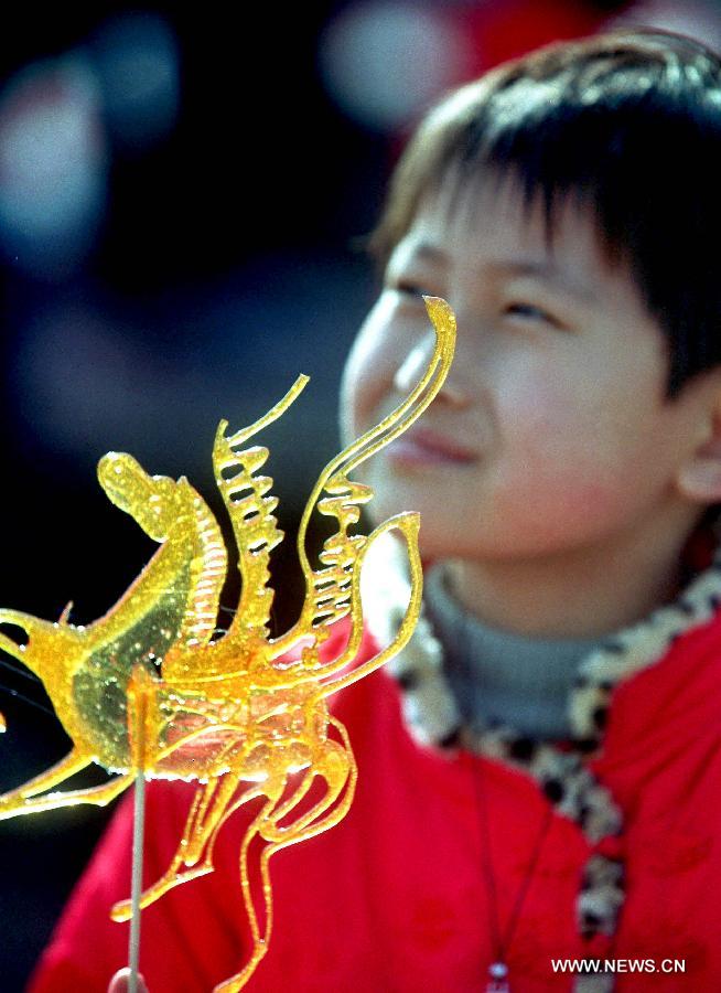 File photo taken on Feb. 17, 2002 shows a boy holding a horse-shaped candy in a temple fair in Zhengzhou, capital of central China's Henan Province. 2002 was the Year of the Horse in the Chinese Zodiac. Chinese Zodiac is represented by 12 animals to record the years and reflect people's attributes, including the rat, ox, tiger, rabbit, dragon, snake, horse, sheep, monkey, rooster, dog and pig.(Xinhua/Wang Song) 