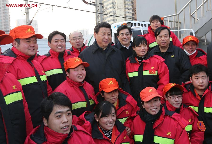 Xi Jinping (C), general secretary of the Communist Party of China (CPC) Central Committee and chairman of the CPC Central Military Commission, poses for a group photo with sanitation workers in the Shoupakou cleaning station of the sanitation center of the Xicheng District in Beijing, capital of China, Feb. 8, 2013. Xi Jinping on Friday visited and extended greetings to laborers including subway construction workers, sanitation workers, police officers and taxi drivers in Beijing, ahead of the Chinese traditional Spring Festival, which starts on Feb. 10 this year. (Xinhua/Liu Weibing) 