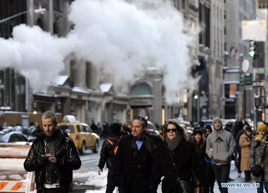 People walk on a street after snow in New York City, on Feb. 9, 2013. A massive blizzard dumped as much as three feet (one meter) of snow in parts of the Northeastern United States, leaving some 650,000 households and businesses without power and two dead by Saturday. (Xinhua/Wang Lei) 