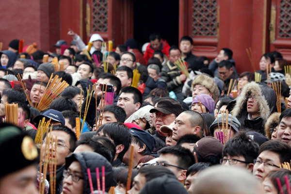 People wait to pray for good fortune as they enter Yonghegong Lama Temple on the first day of the Chinese Lunar New Year in Beijing Feb 10, 2013. (Photo/chinadaily.com.cn)