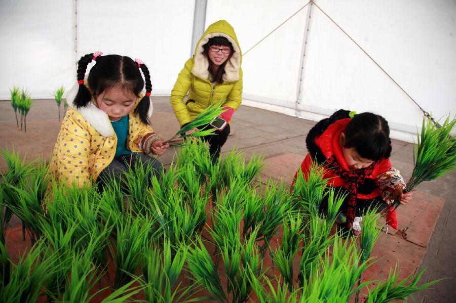 Two girls experience transplanting rice shoots at a local event celebrating Chinese Lunar New Year, or Spring Festival, on the outskirts of Shanghai, east China, Feb. 10, 2013. Various activities were held all over China on Sunday to celebrate the Spring Festival, marking the start of Chinese lunar Year of the snake. The Spring Festival falls on Feb. 10 this year. (Xinhua/ Zhuang Yi)