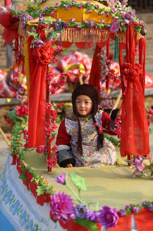 A girl experiences land boat dancing at a local event celebrating Chinese Lunar New Year, or Spring Festival, in Linhuan Township, Huaibei City, east China's Anhui Province, Feb. 10, 2013. Various activities were held all over China on Sunday to celebrate the Spring Festival, marking the start of Chinese lunar Year of the snake. The Spring Festival falls on Feb. 10 this year. (Xinhua/Wan Shanchao) 