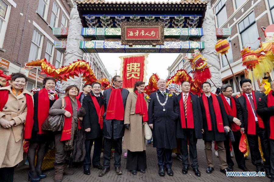 Mr. Henk Kool, deputy mayor of the Hague, pose for a photo with members of a dragon dance team at the China Town during the Chinese Spring Festival celebration in the City Centre of the Hague, Feb. 9, 2013. (Xinhua/Rich Nederstigt) 